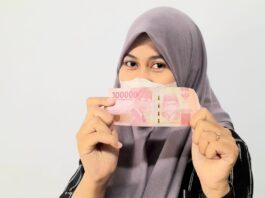 Gadis cantik menunjukkan uang asli rupiah