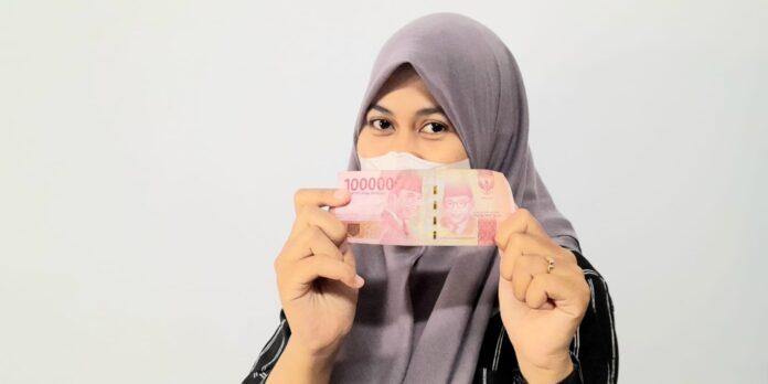 Gadis cantik menunjukkan uang asli rupiah